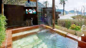 A hot tub with a view of mountains, a wooden deck, and a decorative wall. - Villa Katsuyama Avail (Kyonan)
