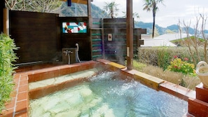 A hot tub with a view of mountains, a wooden deck, and a decorative wall. - Villa Katsuyama Avail (Kyonan)