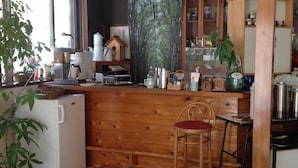 L’intérieur d’un chalet en bois comprend un coin cuisine, une table à manger et une chaise.