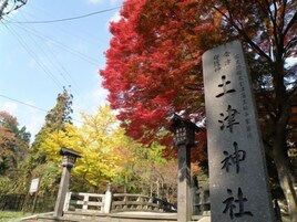 Un monumento de piedra con caracteres japoneses, un farol tradicional japonés y un puente de madera.
