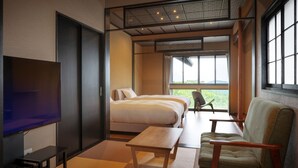A modern hotel room with a TV, two beds, a sofa, a small table, and a view of greenery. - Aone Onsen Itto Onsenyado Seigetsu (Kawasaki)