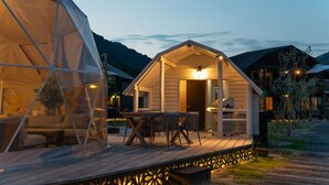 A wooden cabin with a porch, a dining table, and chairs. - LIT Shimanami (Onomichi)