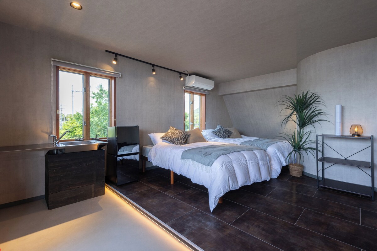 Una camera da letto moderna con un letto, comodini, una scrivania e una pianta in vaso.