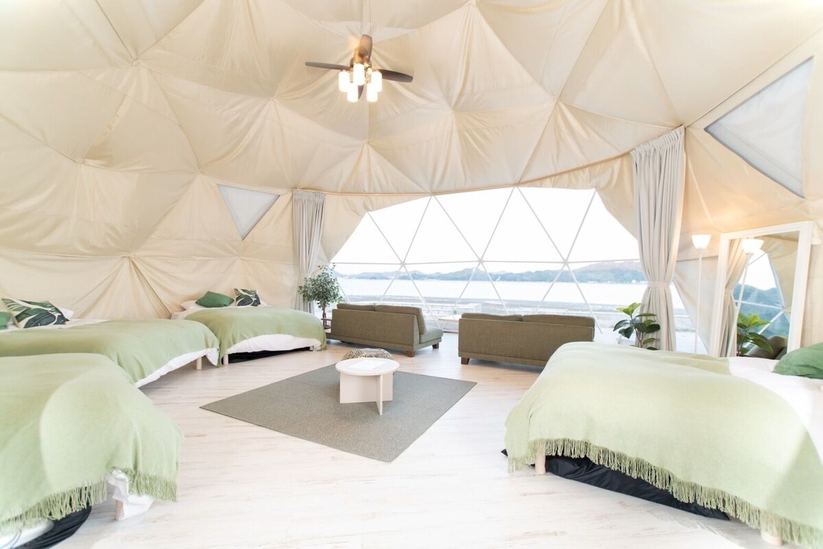 Un alloggio in tenda spazioso con un letto grande, un divano e un tavolino.