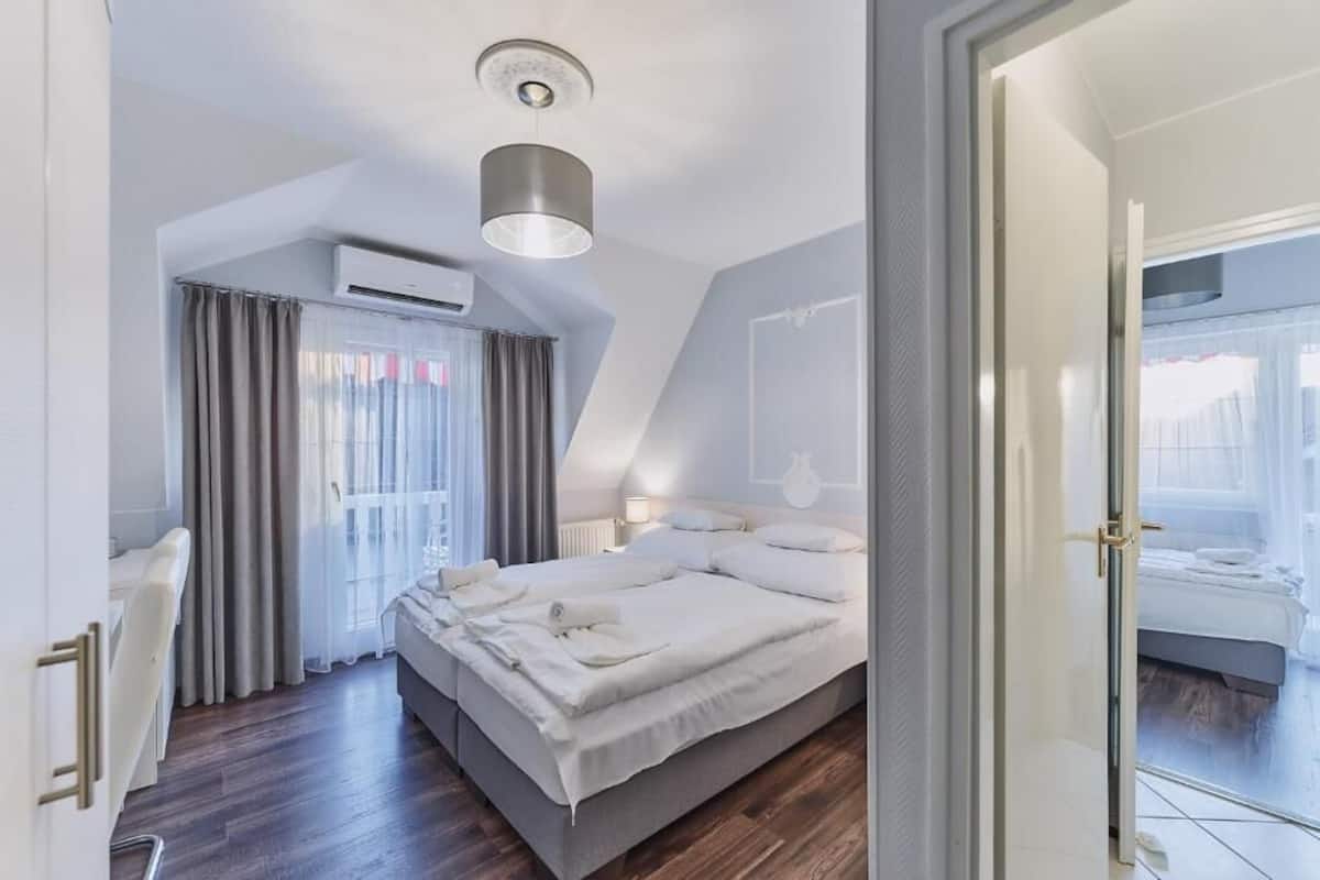 Une chambre moderne avec un grand lit, un bureau et un appareil de climatisation.
