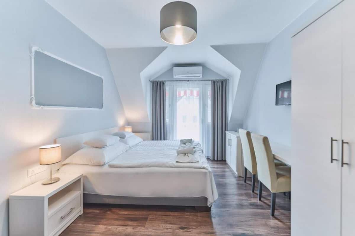 Une chambre moderne comprenant un lit, une table de chevet, une lampe et un bureau avec des chaises.