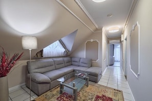 Una sala de estar moderna con un sofá modular, una mesa de centro de vidrio y una lámpara.