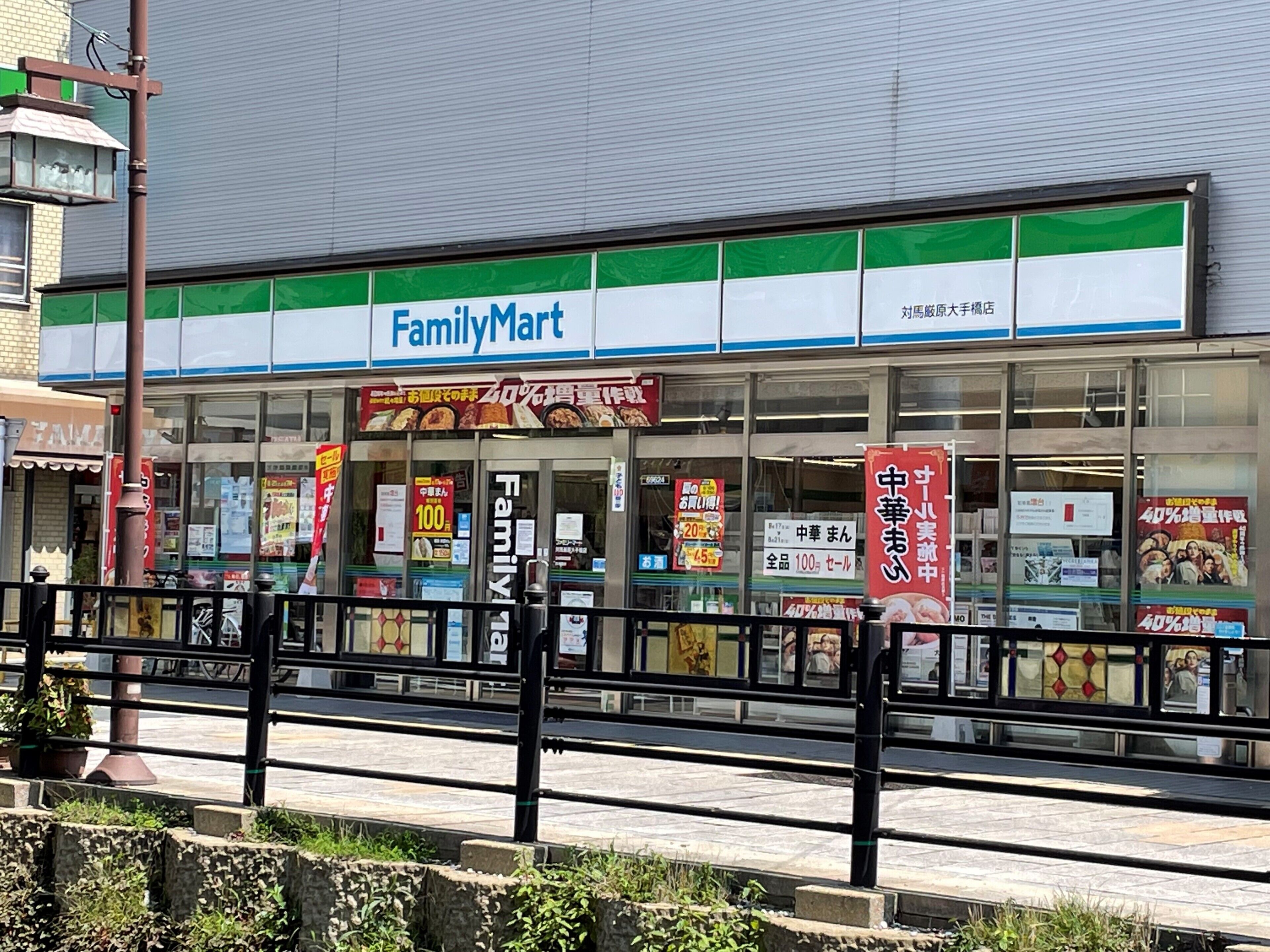 A FamilyMart store with a large sign, promotional posters, and a clear view of the entrance.