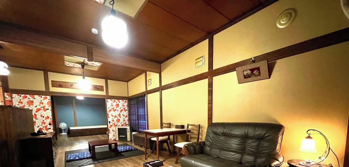 A living room with a sofa, a dining table, and a TV.