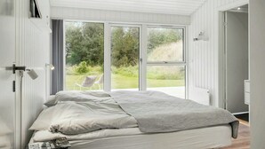 Quarto com cama, janela e porta.