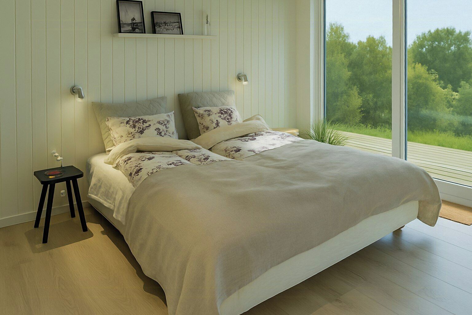 Una camera da letto con un letto grande, un comodino, una scrivania e una finestra vista verde.