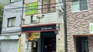 A multi-story building with a B-line sign, a GinGembre restaurant, and a Takahira residence.