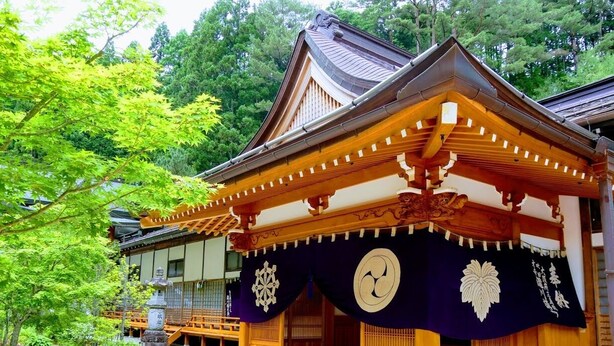 A traditional Japanese building with a wooden structure, a covered entrance, and a stone statue. - Koyasan Bekkaku Honzan Myo'o-in Temple Lodging (Koya)