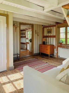 Una habitación con vigas de madera, un aparador de madera, un espejo y una ventana con vistas.