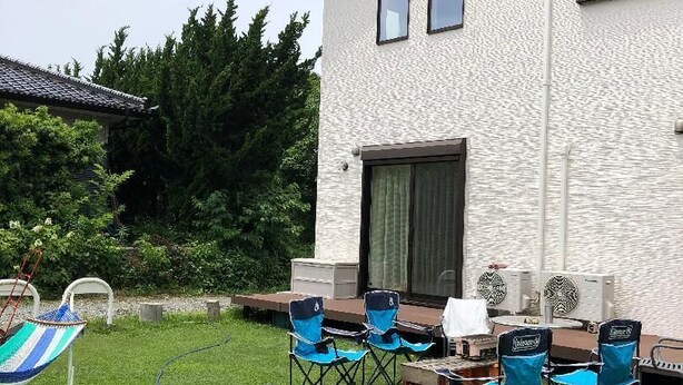 Un patio con mobiliario exterior, una parrilla y un ventilador.