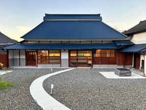 Un edificio japonés tradicional con un camino sinuoso que lleva a una entrada de madera.