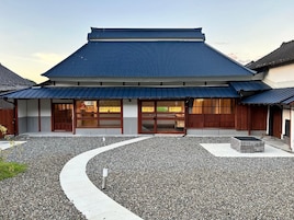 Un edificio japonés tradicional con un camino sinuoso que lleva a una entrada de madera.