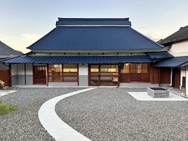 Un edificio japonés tradicional con un sendero de grava curvo que lleva a la entrada.