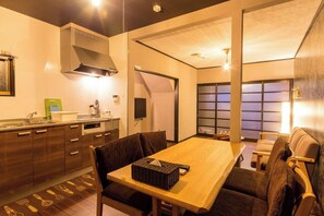 A compact kitchen with a dining area, a TV, and a sliding door leading to a living space. - Kyo-hiiragi (Kyoto)