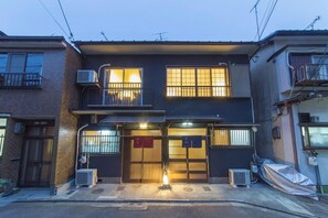 A two-story residential building with a dark facade, a balcony on the upper floor, and a gated entrance. - Kyo-hiiragi (Kyoto)