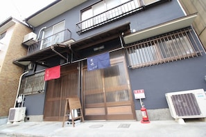 A building with a traditional Japanese entrance, air conditioning units, and a fire extinguisher. - Kyo-hiiragi (Kyoto)