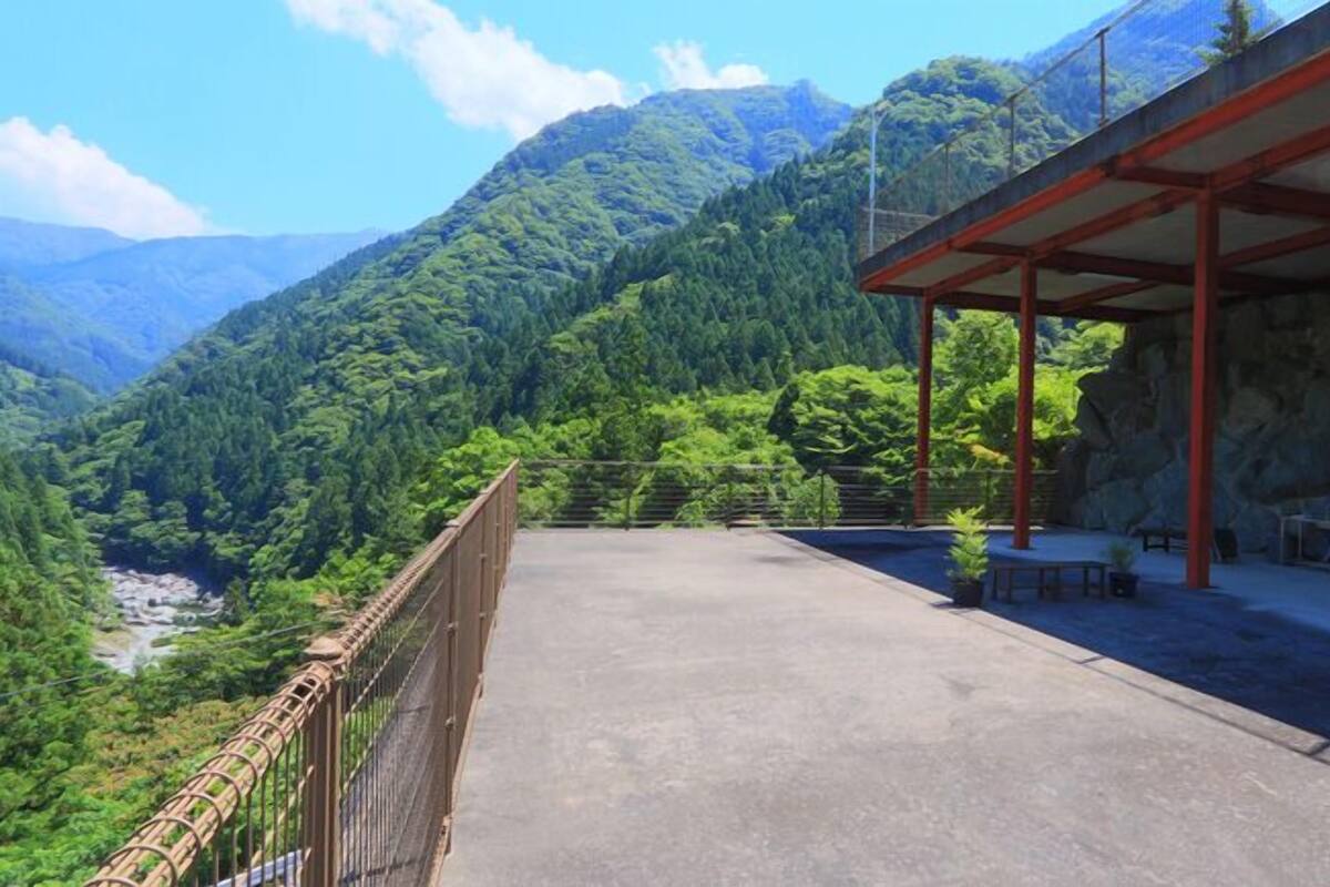 A covered outdoor area with a view of a mountainous landscape.