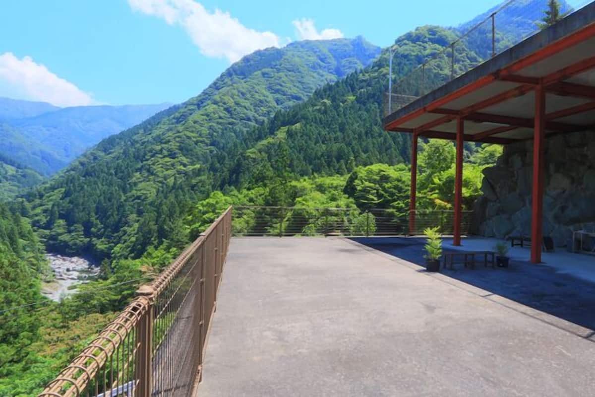 A covered outdoor area with a view of a mountainous landscape.