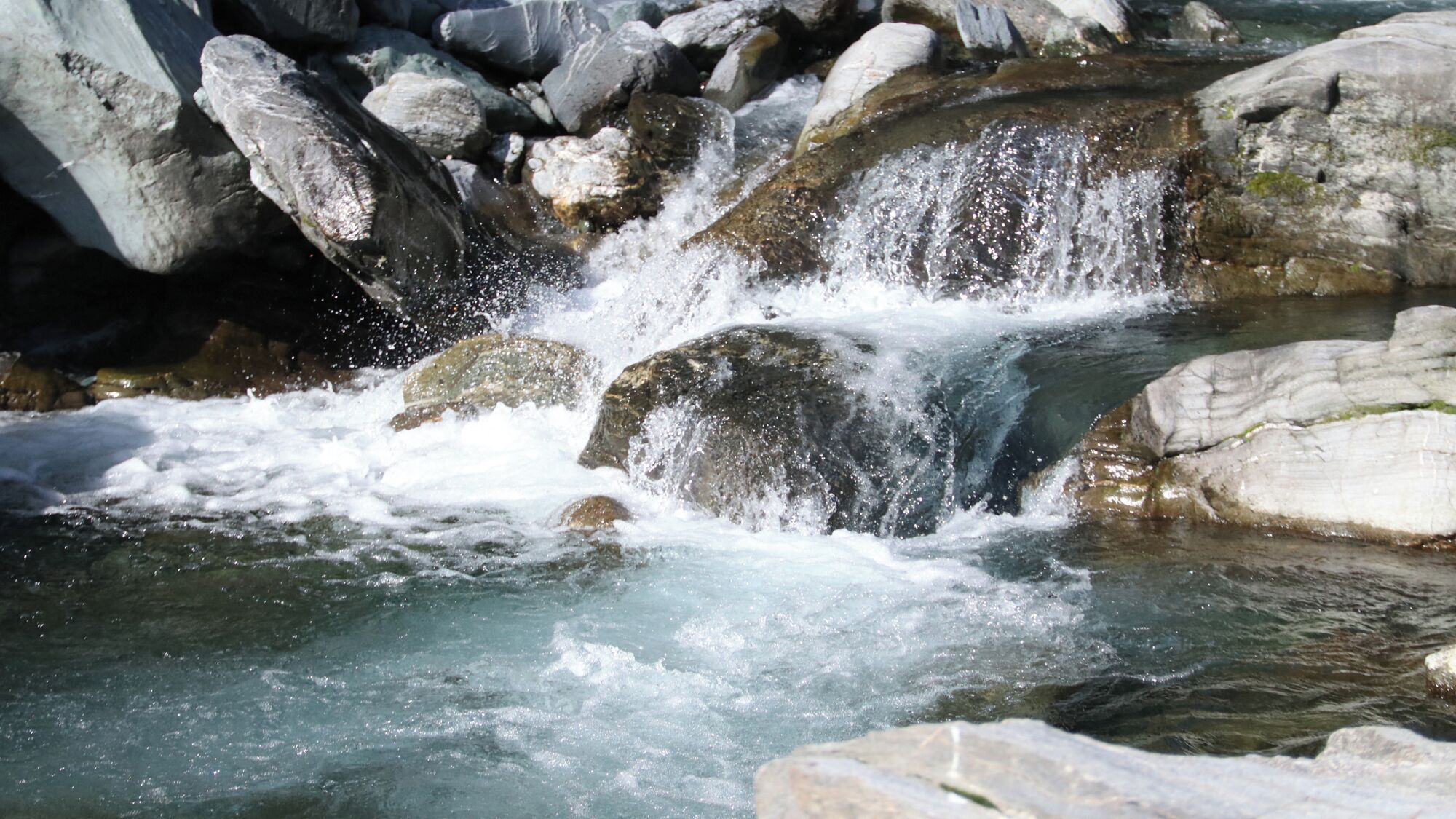 Een natuurlijke waterpartij met rotsen en stromend water.