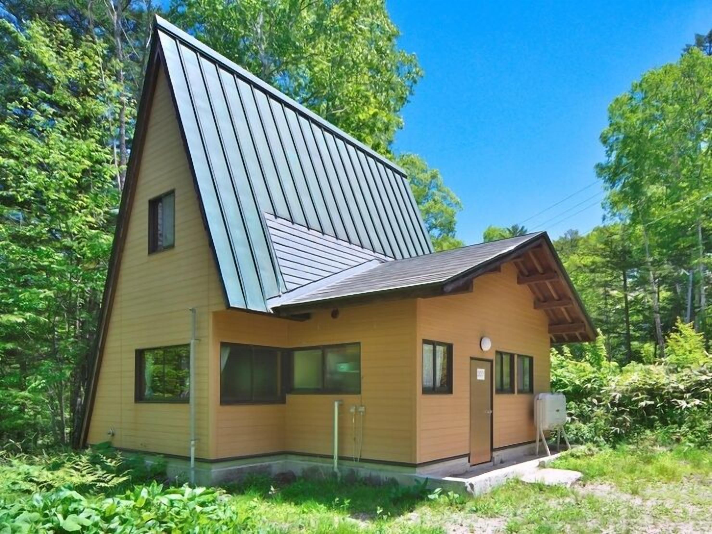 A modern house with a sloped roof, large windows, and a wooden exterior.