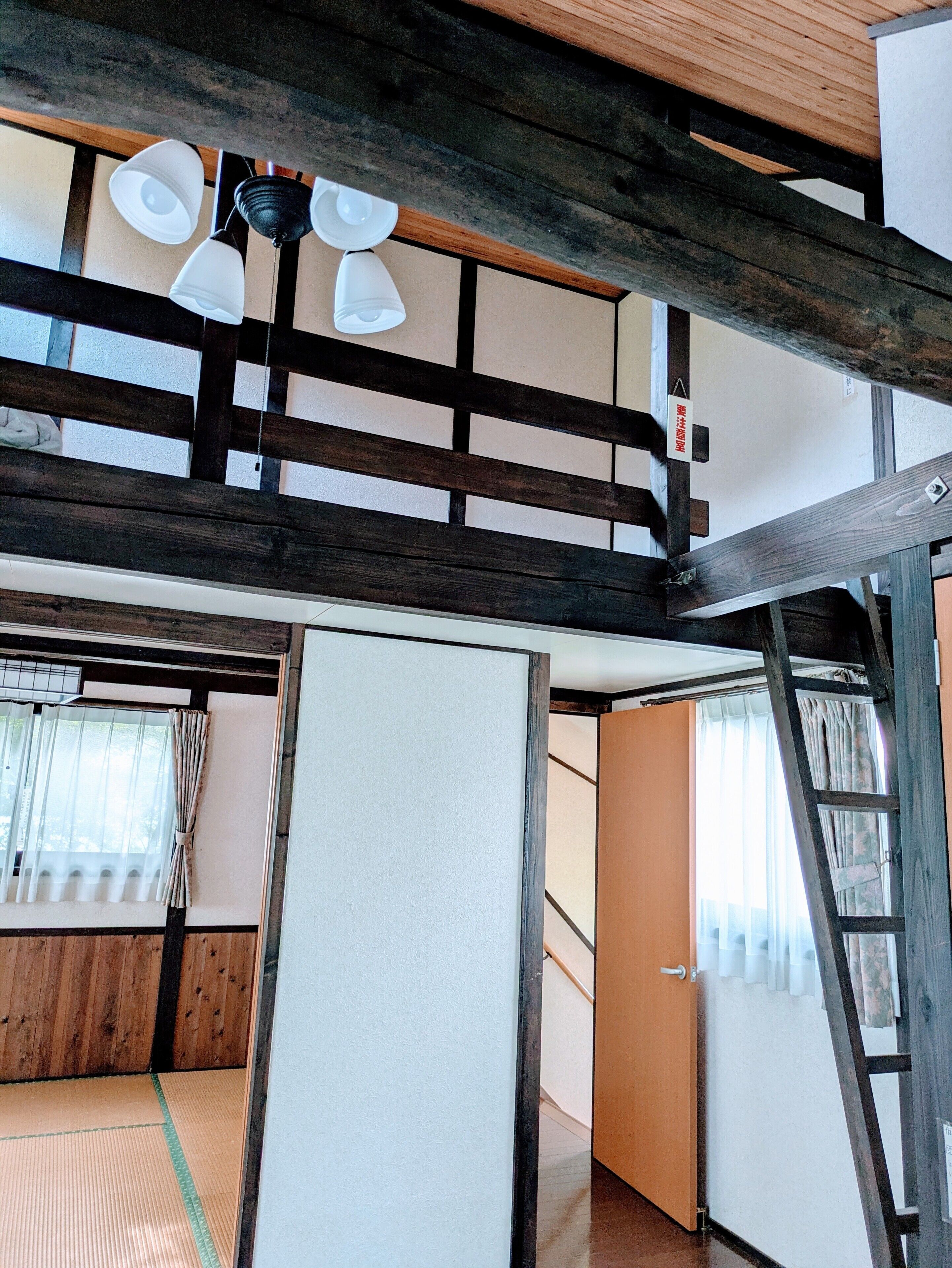Una habitación tradicional japonesa con suelo de tatami, techo de madera y puertas correderas.