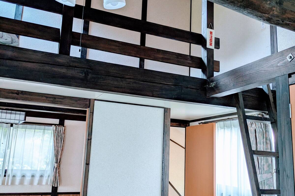 Ein traditioneller japanischer Raum mit Tatami-Bodenbelag, Holzboden und Schiebetüren.