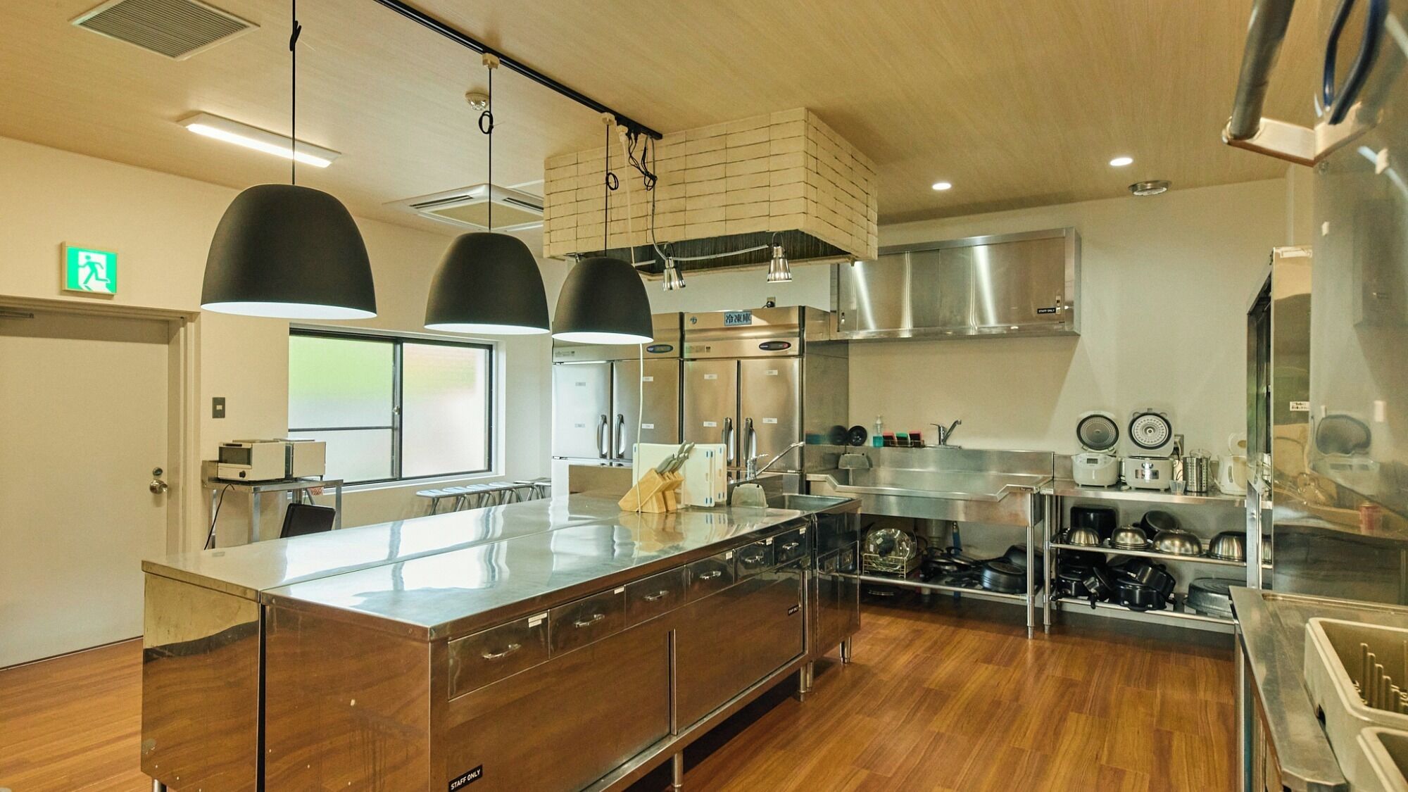 A modern kitchen with stainless steel appliances, a central island, and pendant lighting.