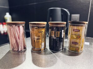 Four jars with different labels on a countertop. - Tabisai Hotel Swell (Fukuoka)