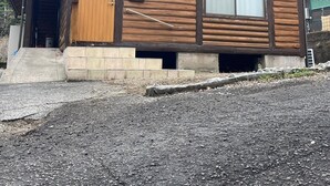 A wooden cabin with a sloped roof, a front door, and a window. - Wood Retreat (Miyazaki)
