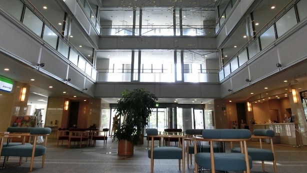 A multi-level atrium with seating areas, a reception desk, and a large potted plant. - Natural Hotspring Hotel Jichikaikan (Kagoshima)