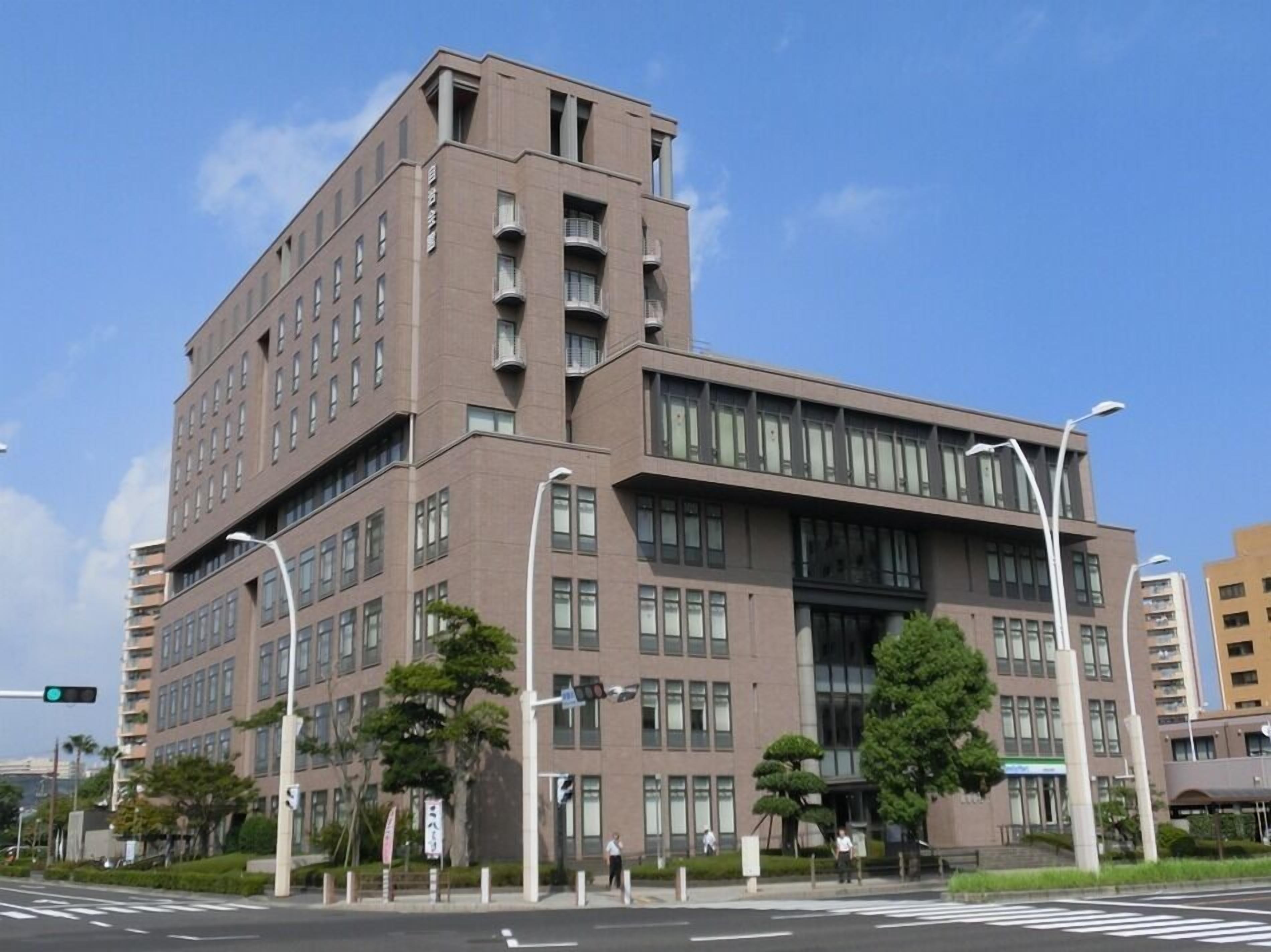 A multi-story building with a modern architectural design, featuring a prominent entrance with large windows and a flat roof.