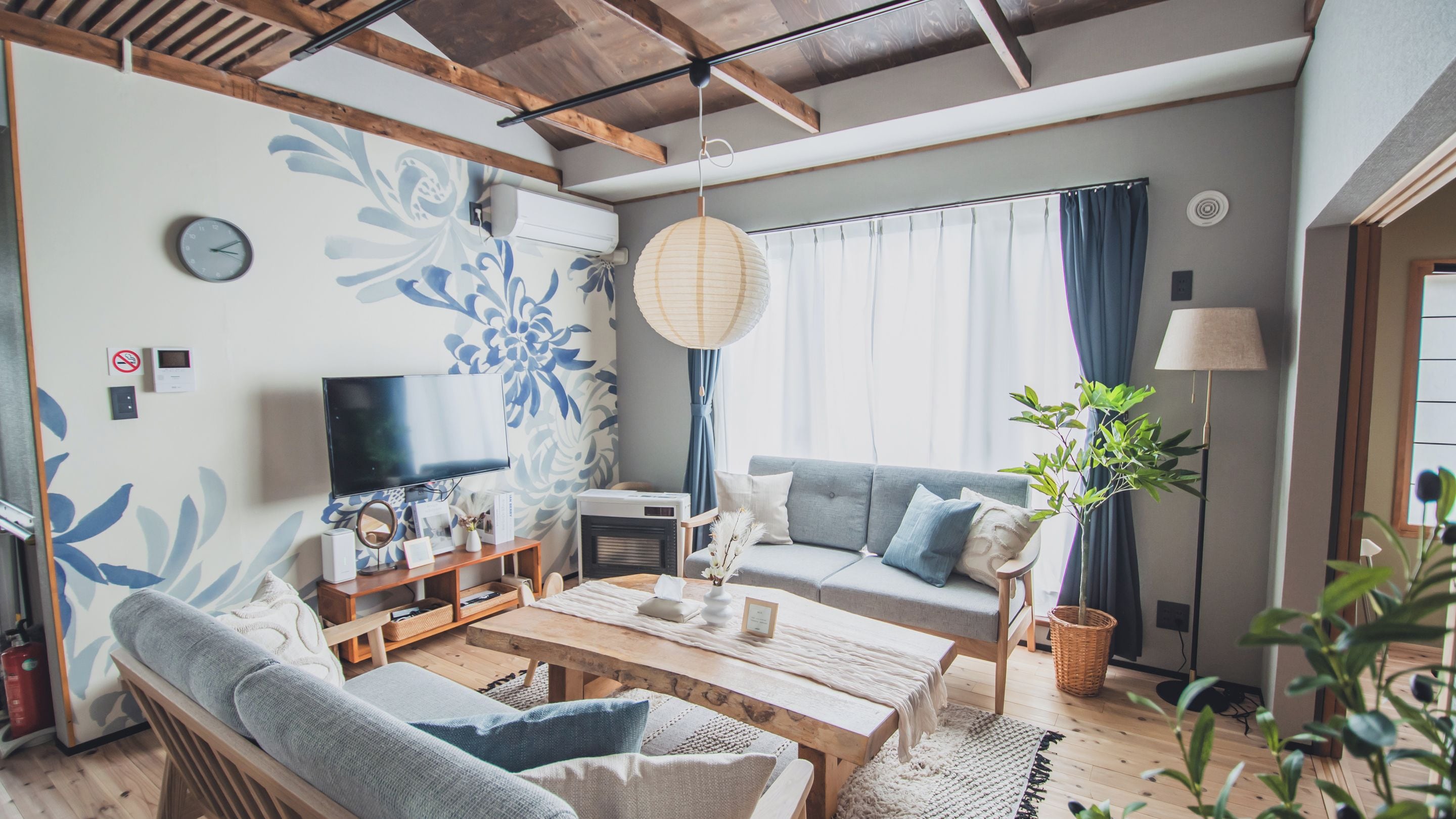 A living room with a sofa, coffee table, TV, and decorative items.