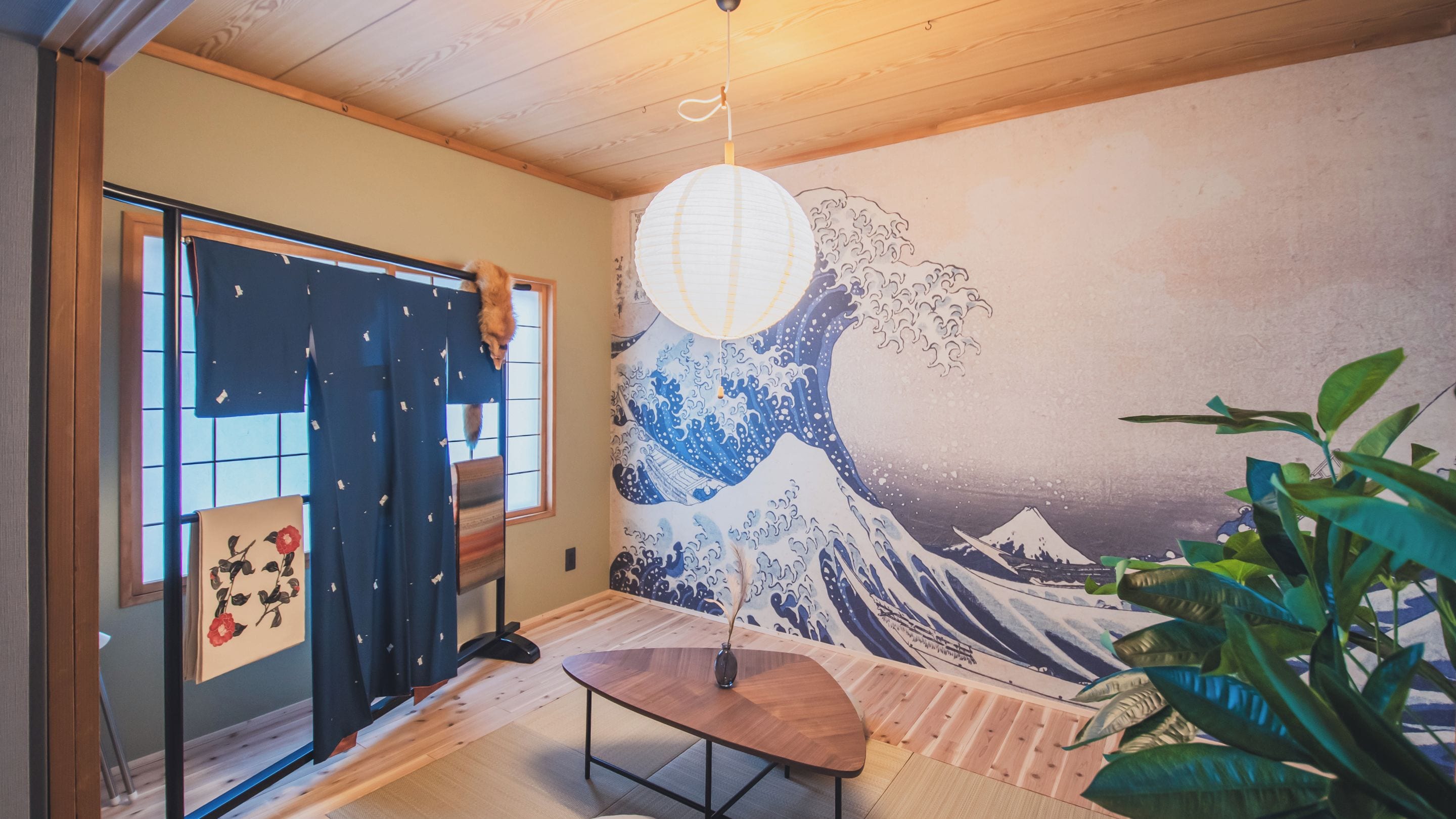 A room with a traditional Japanese shoji screen door, a tatami mat floor, a hanging paper lantern, and a wall mural of Mount Fuji.