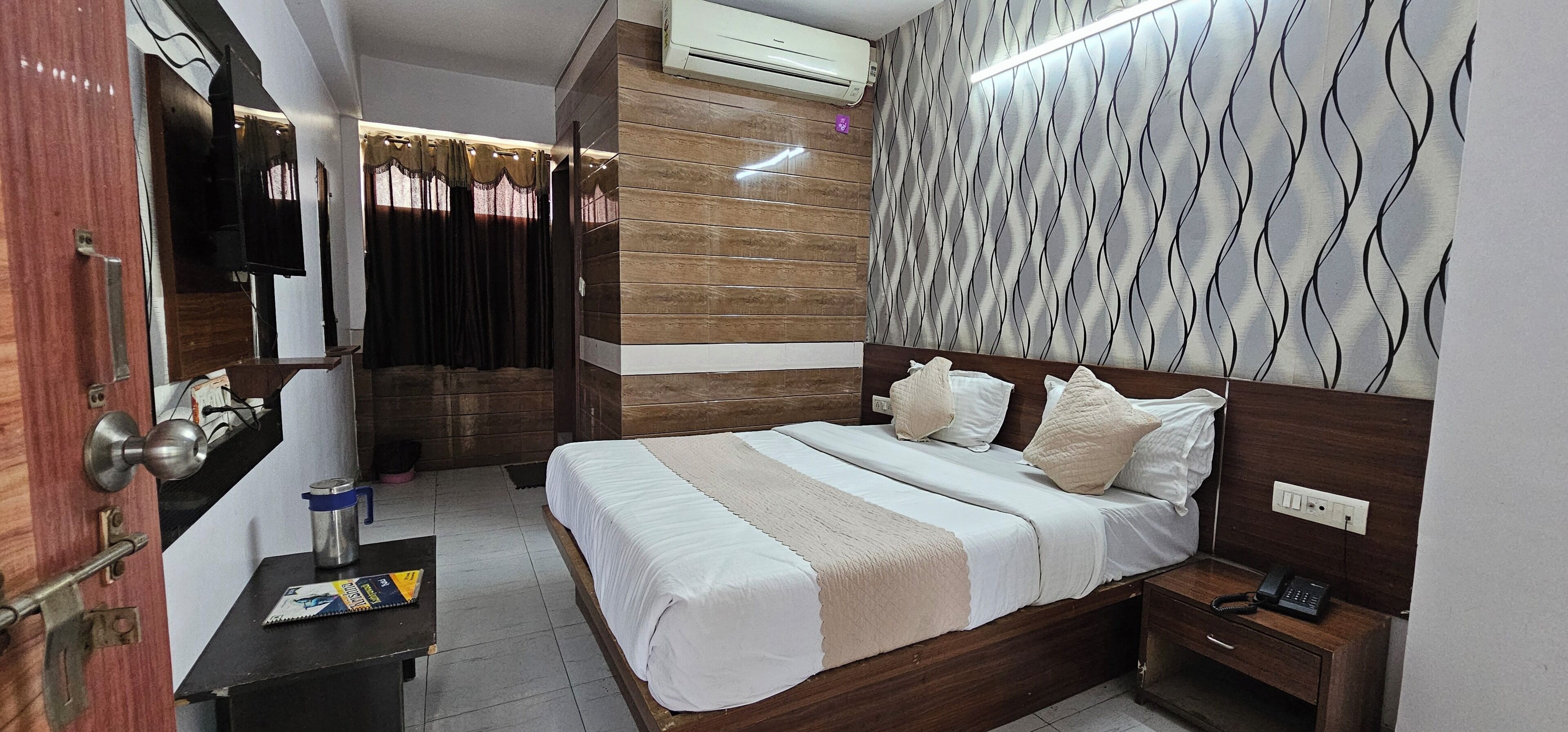 Une chambre d’hôtel équipée d’un lit, d’une table de chevet, d’une commode et d’un appareil de climatisation.