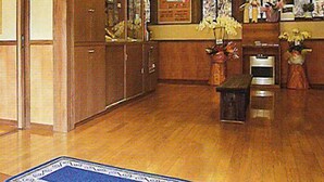 A wooden interior with a reception desk, wooden cabinets, and a large window. - Masugataya (Yonezawa)