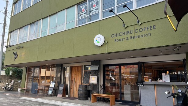Un edificio con un letrero que dice 'Chichibu Coffee Roast & Research' y un banco de madera afuera.
