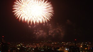 A nighttime cityscape with a large firework display. - Ikaho Bekkan (Nagano)