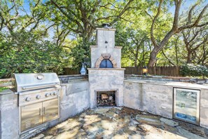 Cucina esterna con barbecue, forno e stufa a legna integrata.