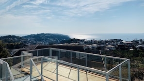 Una zona residencial con vista al mar, una colina y cielo despejado.