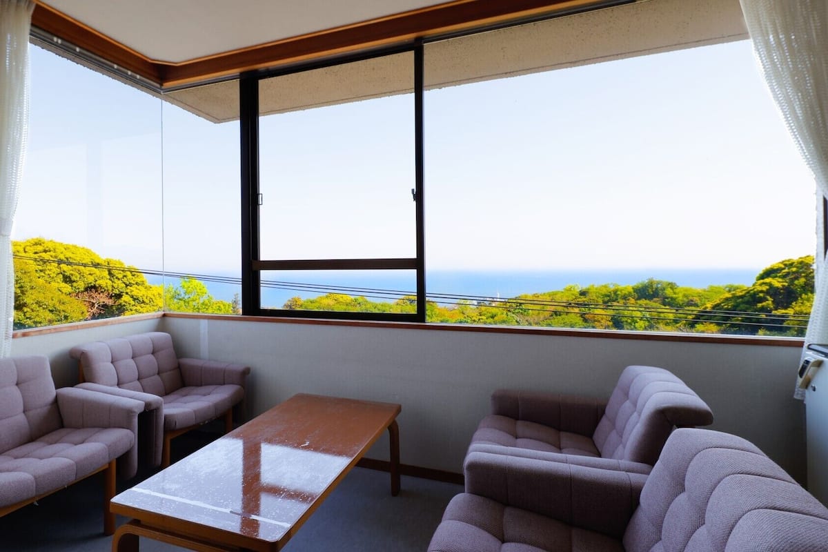 Ein Balkon mit Sitzgelegenheit und Tisch, mit Blick auf eine schöne Landschaft.