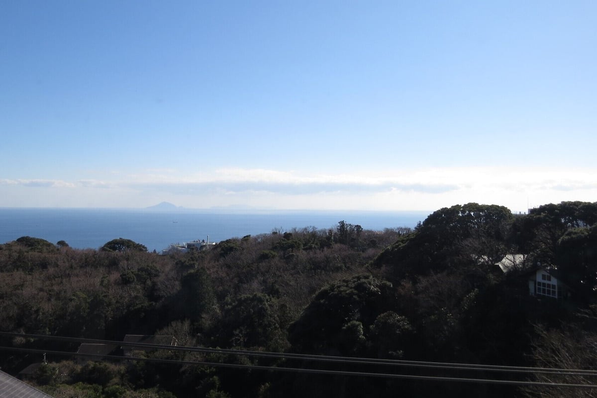 Eine Küstenlandschaft mit Blick auf das Meer und ein fernes Gebirge.