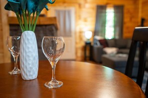 Ein Holztisch mit einer weißen Vase und zwei Gläsern für Wein.