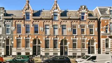 Een rij traditionele bakstenen herenhuizen met gelijke raamontwerpen en een centraal portaal.