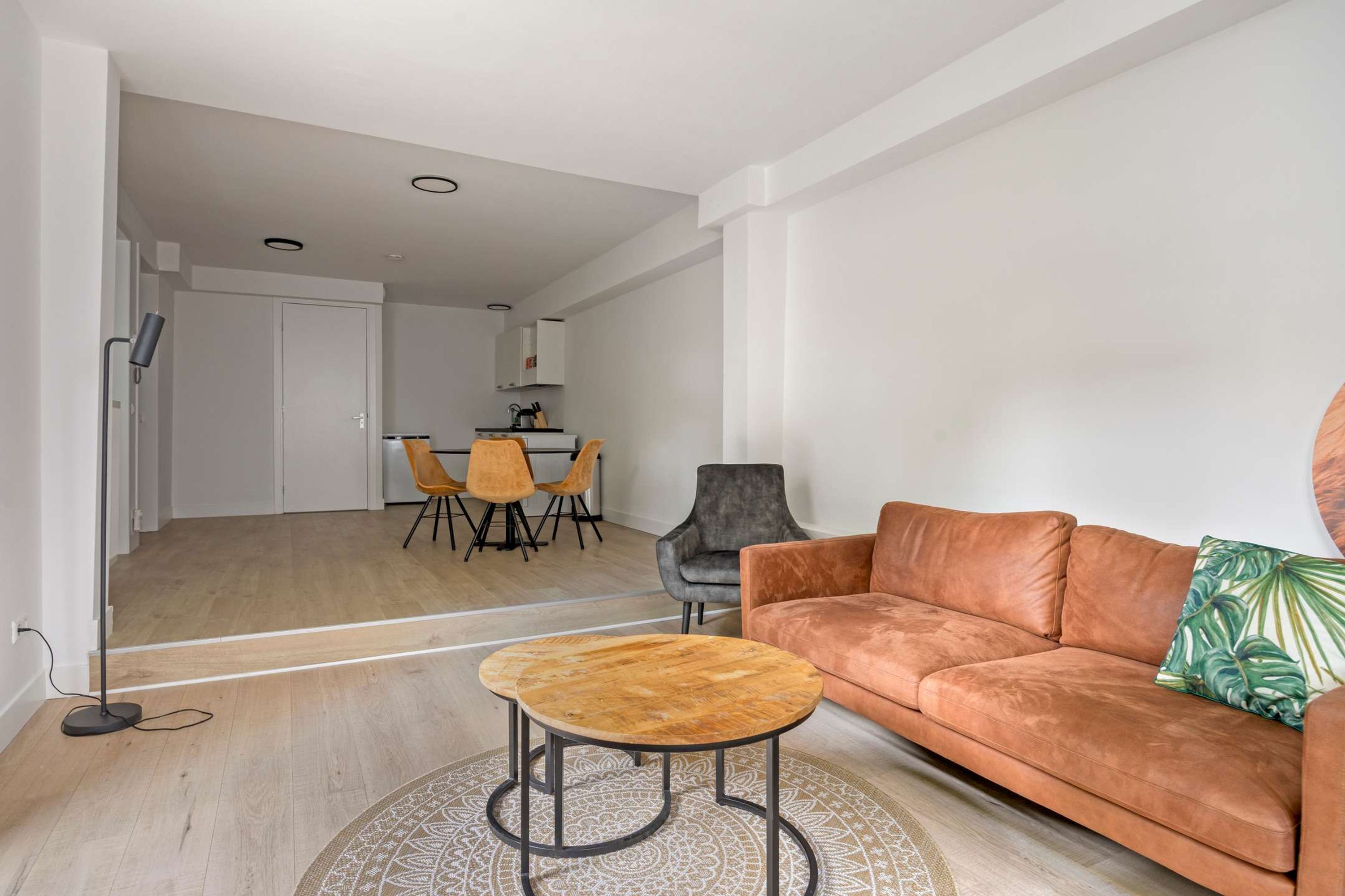 Una sala de estar moderna con un sofá, una mesa de centro y un comedor con sillas.