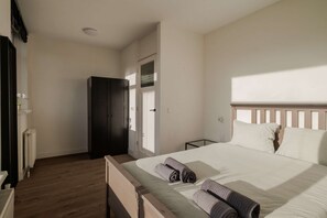 A bedroom with a bed, a wardrobe, a radiator, and a door. - Modern 2BR Apartment Near Rotterdam Central Station (Rotterdam)